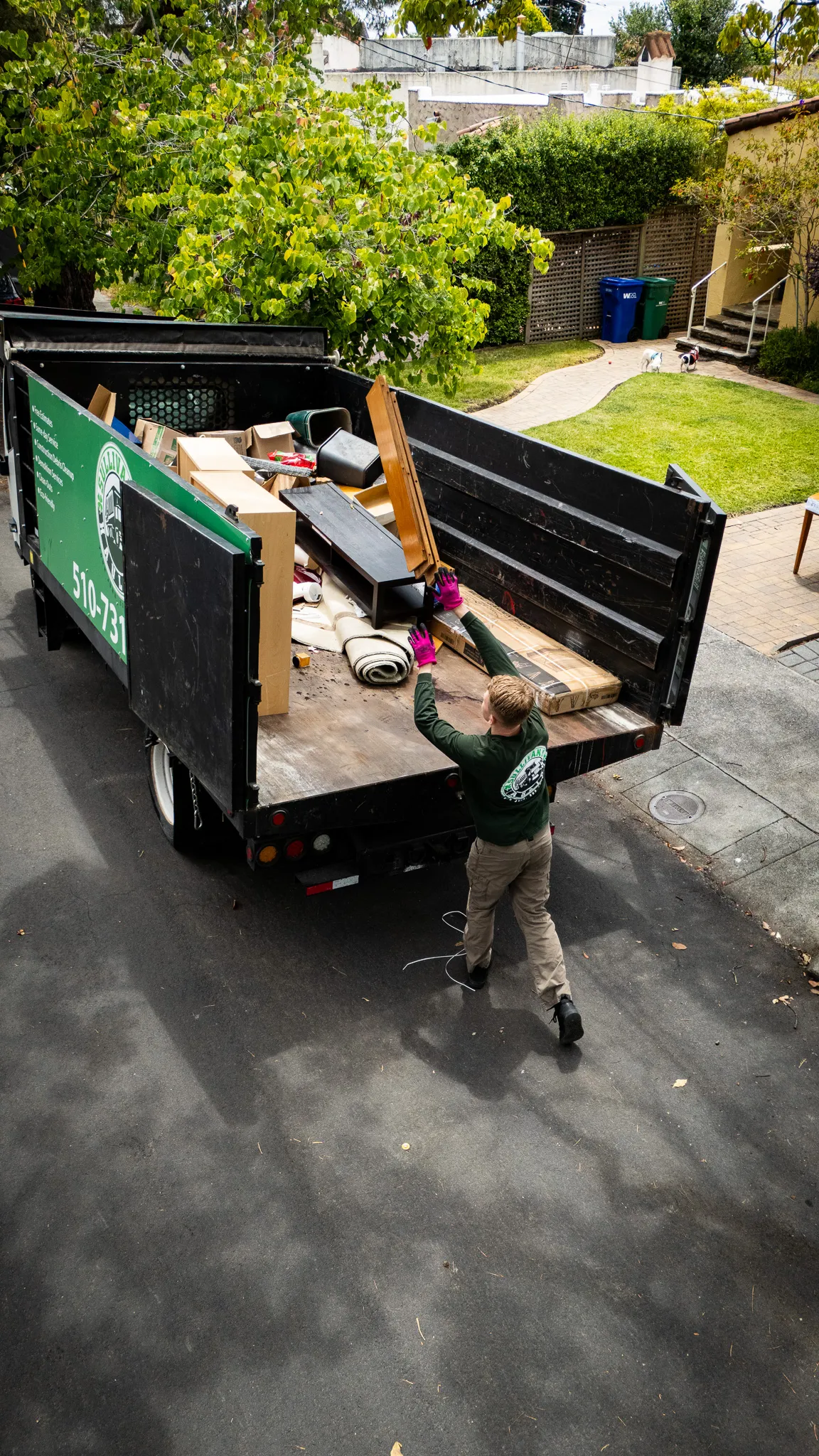 A crew member loading lumber into the back of the truck on a residential driveway