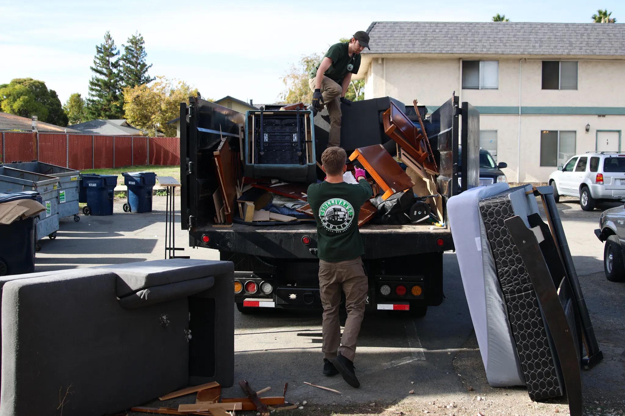 The Sullivan's Hauling truck loaded with furniture and mattresses outside an apartment building